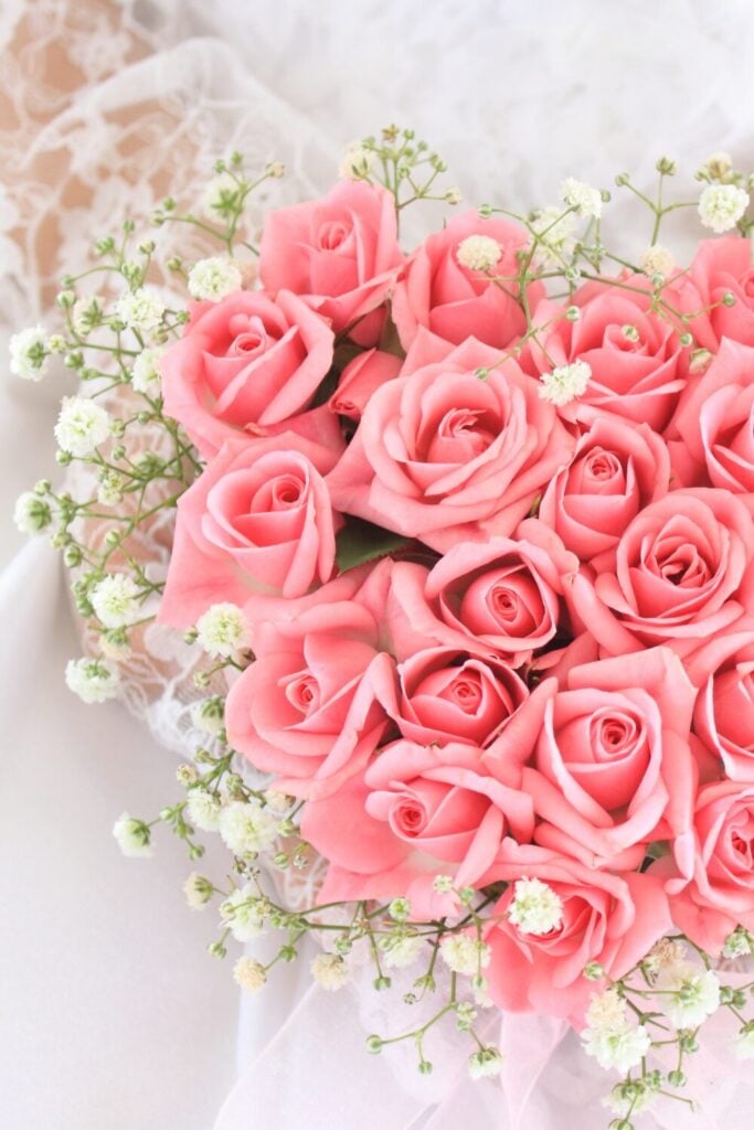 Compact bridal bouquet with pink roses and delicate white Baby’s Breath, exuding elegance and simplicity.