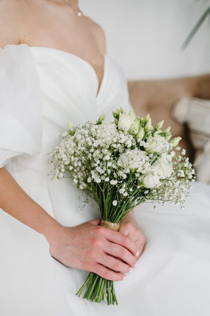 Minimalist white bridal bouquet with lisianthus and Baby’s Breath, tied with twine for a rustic yet elegant finish.