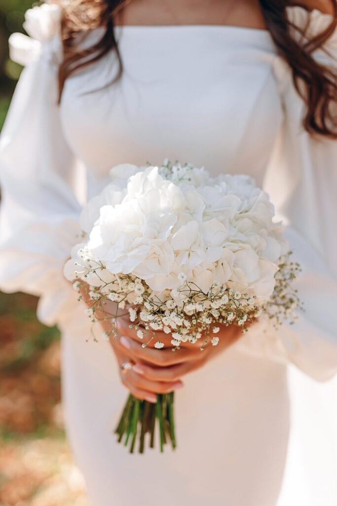 White bridal bouquet featuring hydrangeas and Baby’s Breath, ideal for a modern and minimalist wedding look.