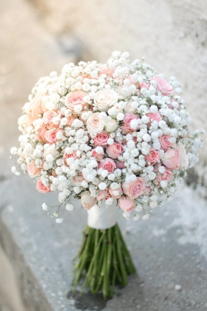 Rounded bridal bouquet with pink spray roses and Baby’s Breath, offering a soft and elegant wedding aesthetic.
