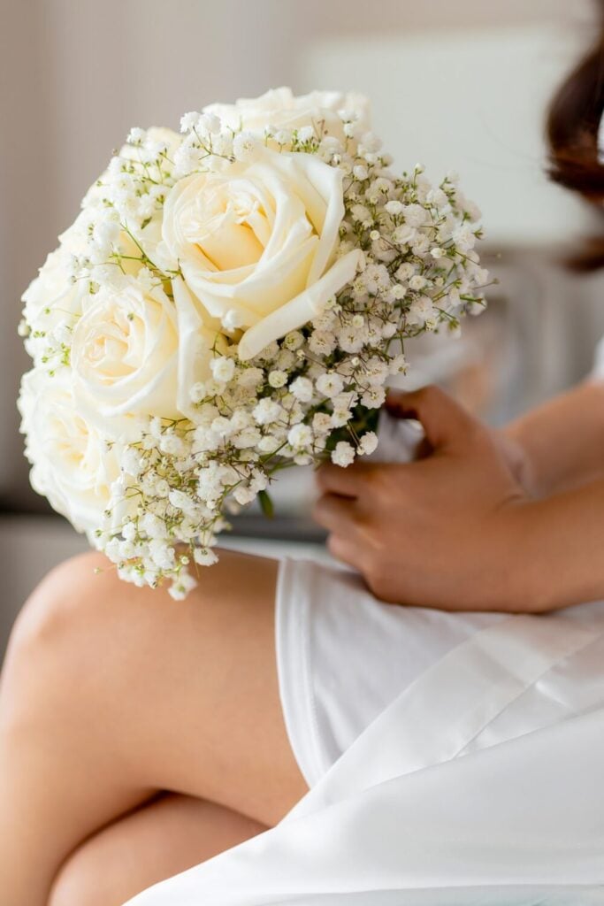 Classic bridal bouquet featuring cream roses surrounded by delicate baby's breath