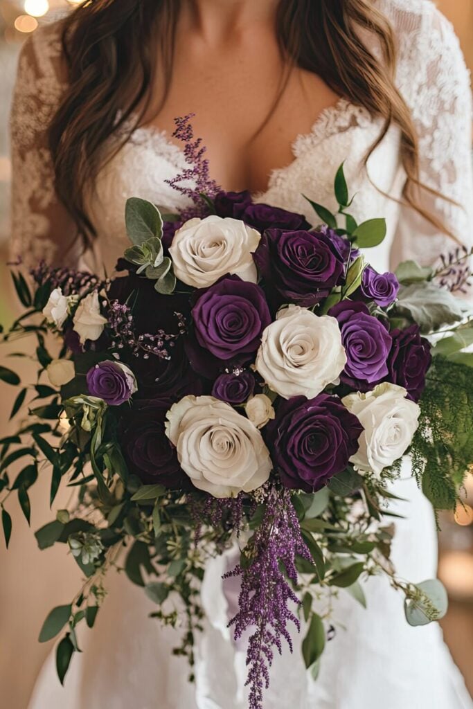 Romantic bridal bouquet with purple and white roses, flowing greenery, and delicate lavender sprigs.