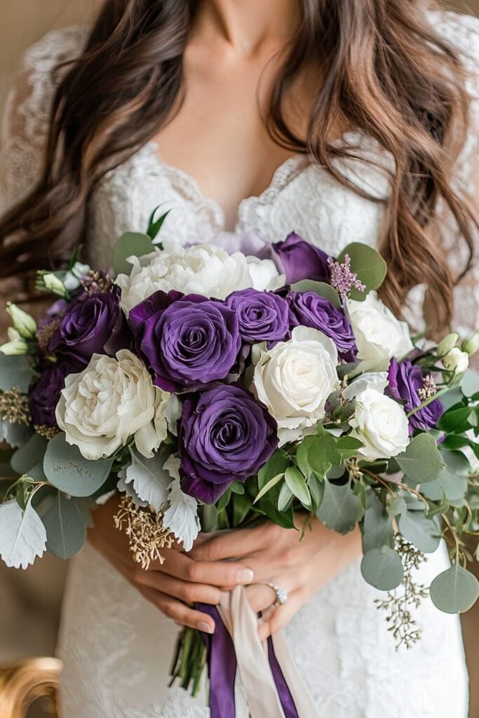 Elegant bridal bouquet with purple and ivory roses, eucalyptus, and trailing ribbons.