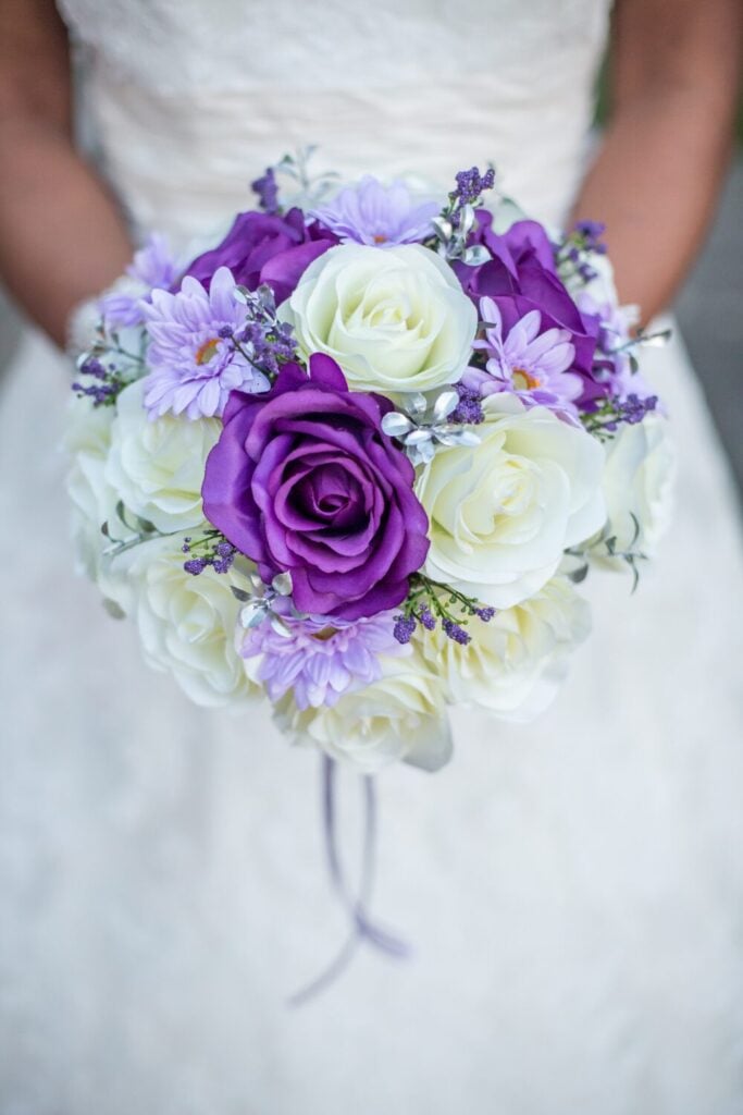Compact purple and white rose wedding bouquet with lavender daisies and accents.