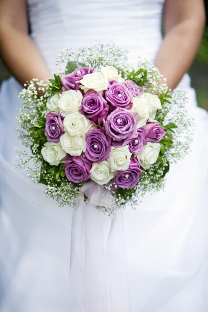 Lavender and white rose wedding bouquet with baby’s breath and sheer white ribbon.
