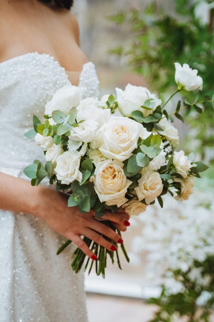 Classic white rose bridal bouquet with creamy white roses, lisianthus, and soft eucalyptus foliage