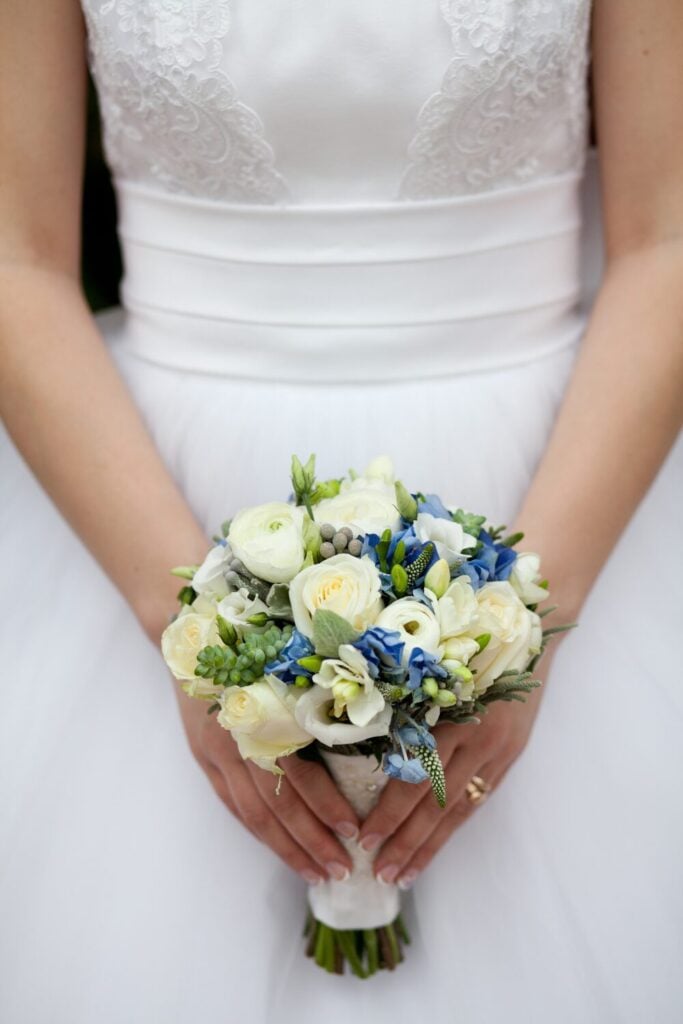 Blue and White Rose Wedding Bouquet held by a bride
